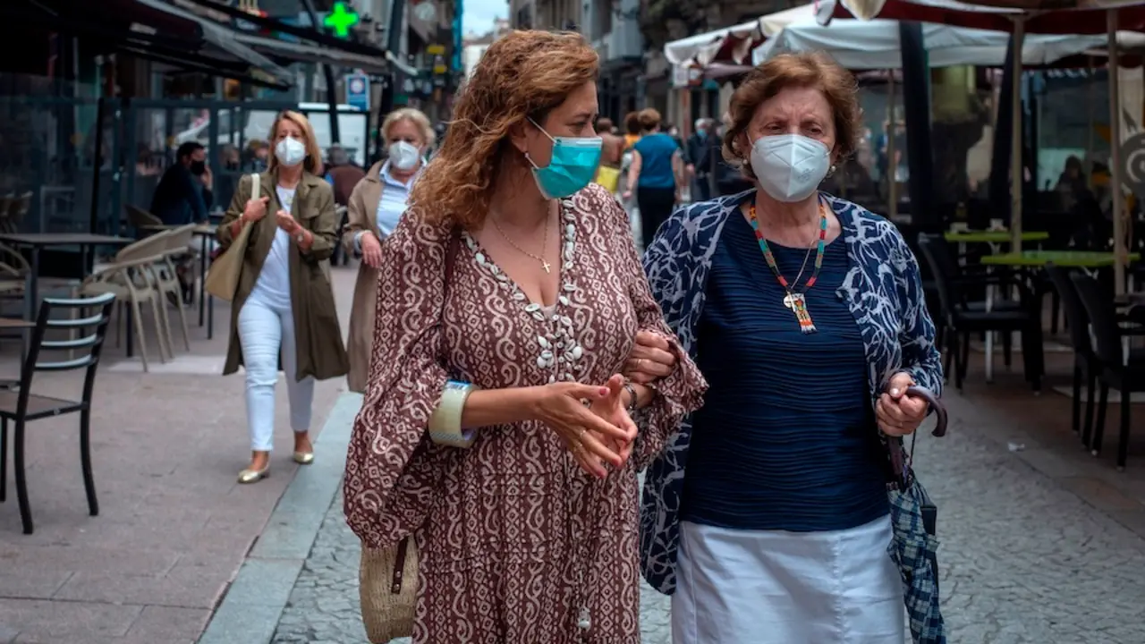 OURENSE, 18/06/2021.- Dos mujeres caminan con mascarilla por una c&Egrave;ntrica calle de Ourense, este viernes. El presidente del Gobierno, Pedro S&middot;nchez, ha anunciado este viernes que la pr&Ucirc;xima semana habr&middot; un Consejo de Ministros extraordinario en el que se decidir&middot; que la mascarilla a causa de la pandemia de coronavirus deje de ser obligatoria en espacios al aire libre a partir del s&middot;bado 26 de junio. EFE/ Brais Lorenzo
