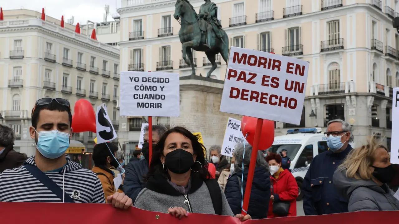 Archivo - Una mujer con un cartel en el que se lee: `Morir en paz es un derecho&acute; durante una concentraci&oacute;n de Derecho a Morir Dignamente en la Puerta del Sol, en Madrid (Espa&ntilde;a), a 18 de marzo de 2021. Derecho a Morir Dignamente se manifiesta para dar apo