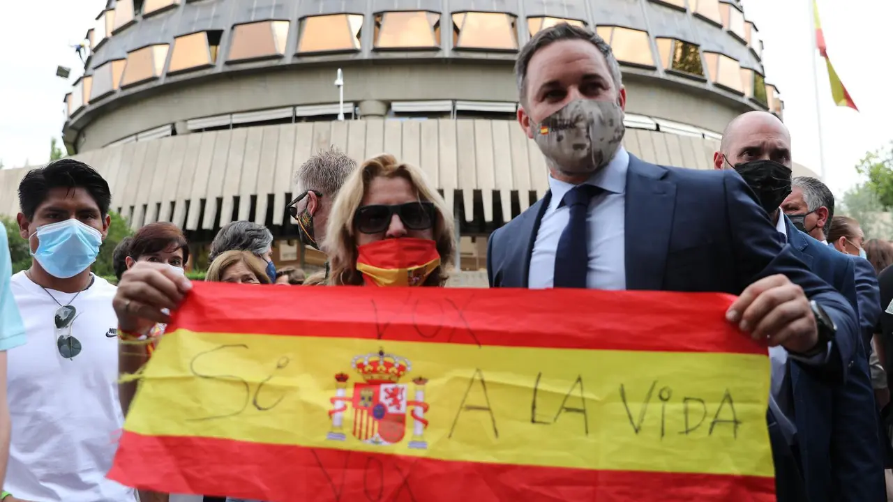 El presidente de Vox, Santiago Abascal, y una mujer sostienen una bandera de Espa&ntilde;a contra la ley de eutanasia, en el Tribunal Constitucional, a 16 de junio de 2021, en Madrid (Espa&ntilde;a).