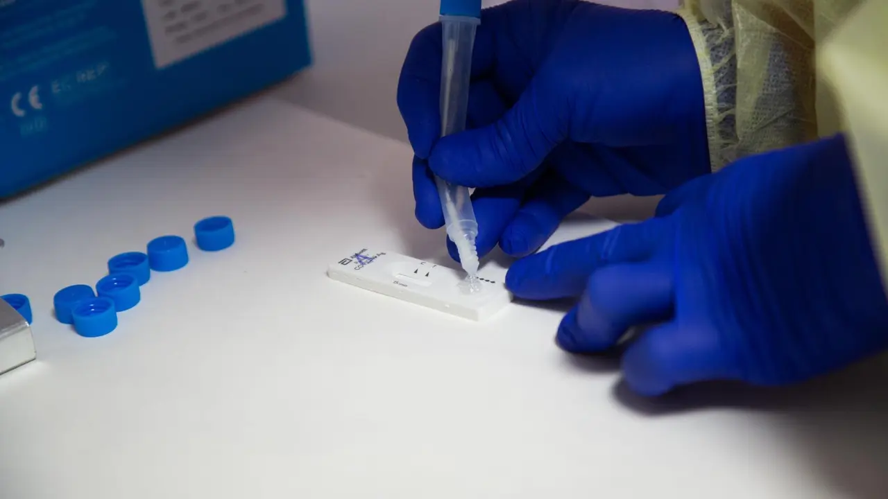 Archivo - Una sanitaria comprueba el resultado de un test de ant&iacute;genos.