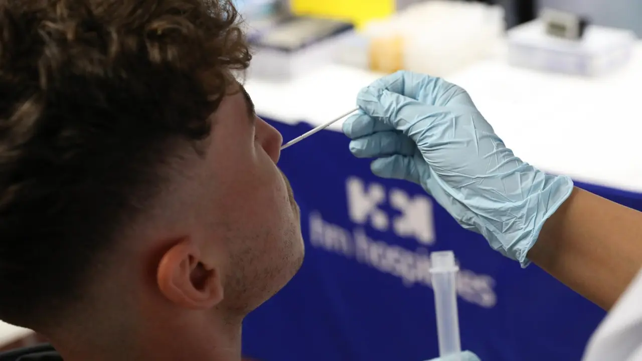 Un sanitario realiza un test de ant&iacute;genos a un hombre.