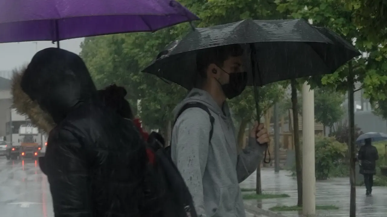 Varias personas bajo lluvia de Santander. / Hardy