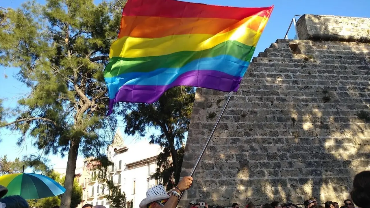 Archivo - Hombre con la bandera LGTBI en la manifestaci&oacute;n del Orgullo en Palma