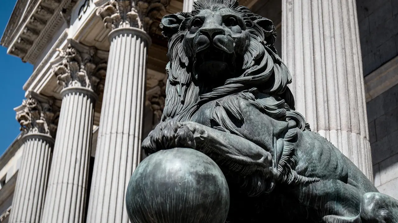 Archivo - Uno de los emblem&aacute;ticos leones que se encuentran delante de la fachada del Congreso de los Diputados en la Plaza de las Cortes de Madrid.