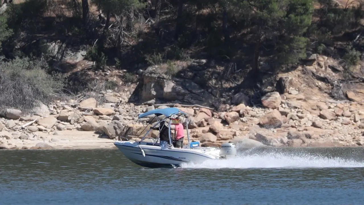 Un grupo de personas montan en una lancha en el pantano de San Juan.