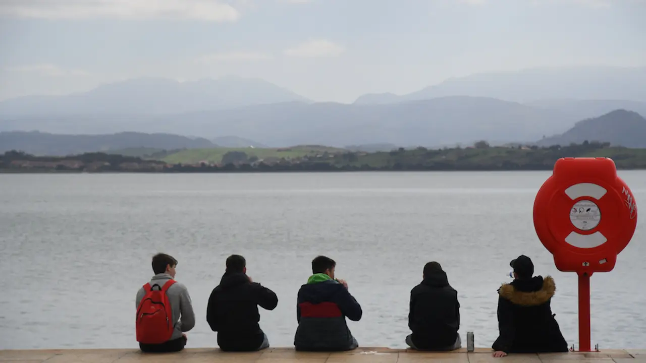Varios j&oacute;venes sentados frente a la bah&iacute;a de Santander. / Hardy