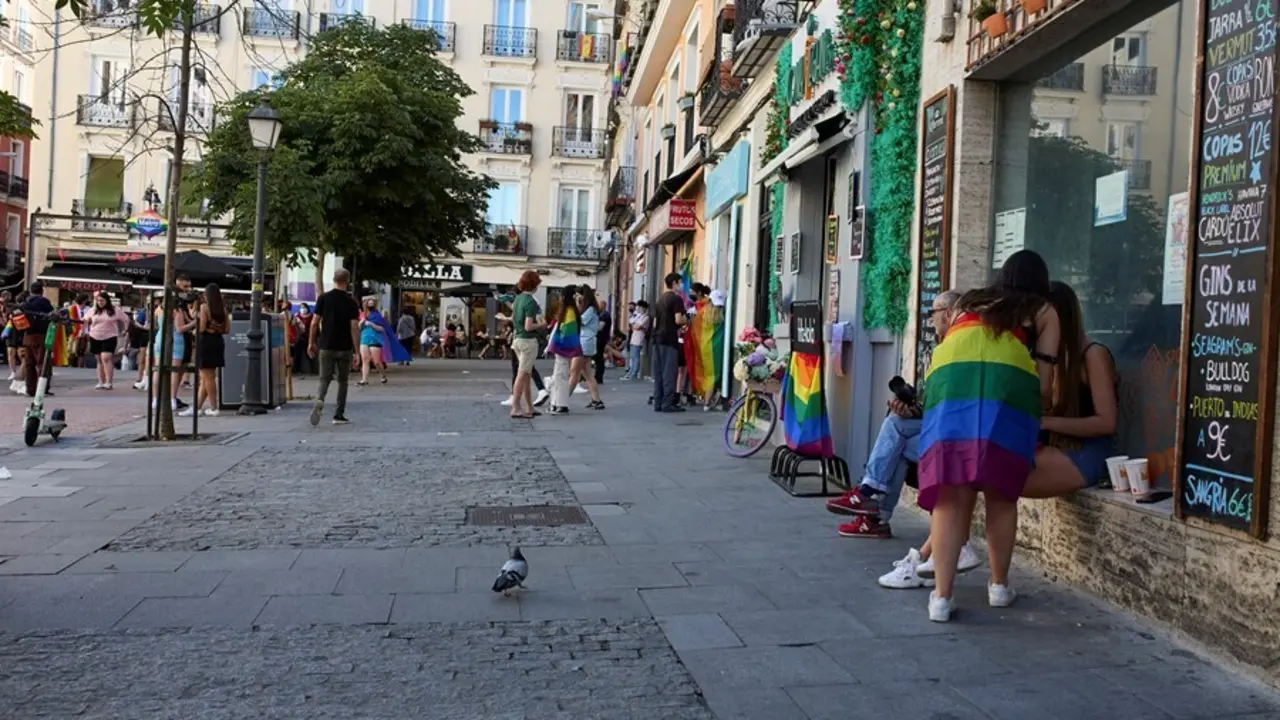 Varias personas con la bandera LGTBI en el barrio de Chueca durante la celebraci&oacute;n del D&iacute;a Internacional del Orgullo LGTBI.