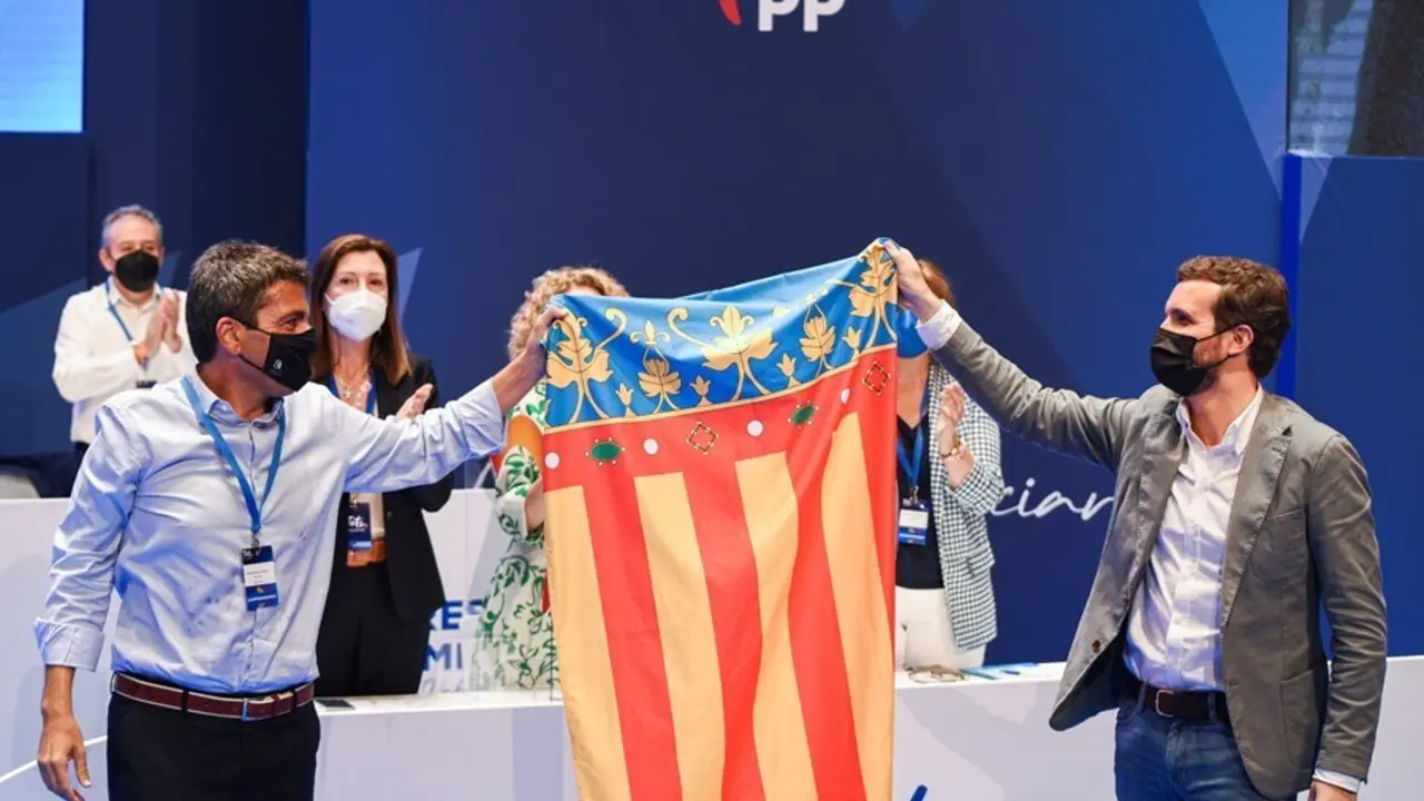 El nuevo l&iacute;der del PP de la Comunidad Valenciana, Carlos Maz&oacute;n (i) y el presidente del PP, Pablo Casado (d) con una bandera de la Comunidad Valenciana, tras haber sido elegido, Carlos Maz&oacute;n presidente del PPCV, en el XV Congreso regional del PPCV