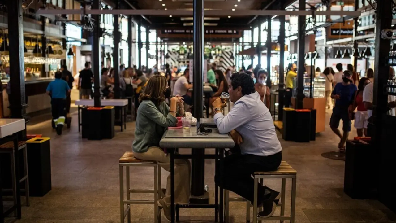 Dos personas sentadas en una mesa durante la reapertura del Mercado de San Miguel en Madrid