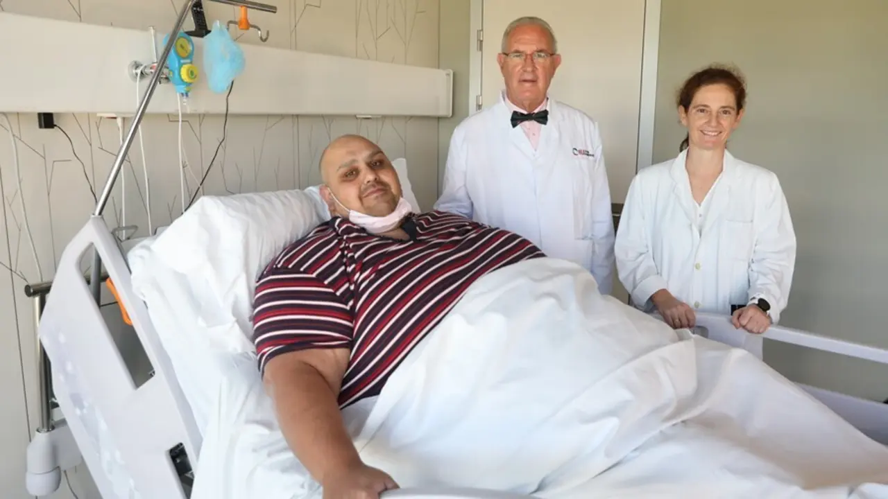 El paciente Emilio Jes&uacute;s Jim&eacute;nez, de 39 a&ntilde;os, posa con el doctor Carlos Ballesta y una m&eacute;dico de su equipo minutos antes de someterse a una cirug&iacute;a de laparoscopia para tratar su obesidad de 308 kilos, en el Hospital Universitario de Moncloa