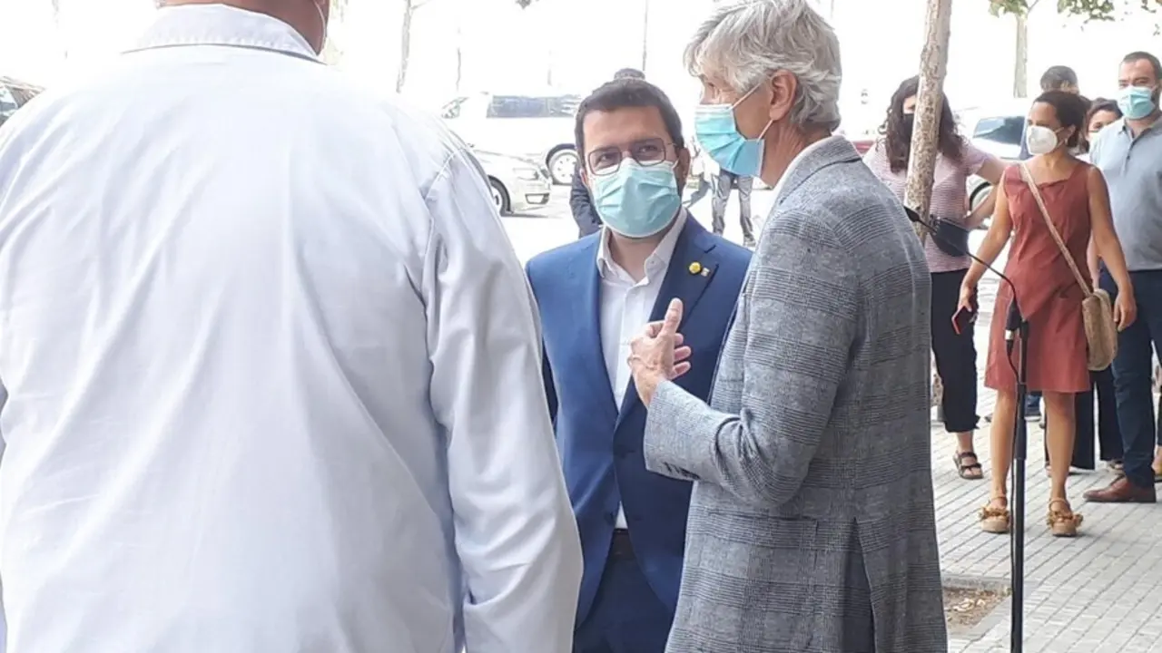 El presidente de la Generalitat, Pere Aragon&egrave;s, conversa con el conseller de Salud, Josep Maria Argimon, y sanitarios del Hospital de Bellvitge tras la rueda de prensa.