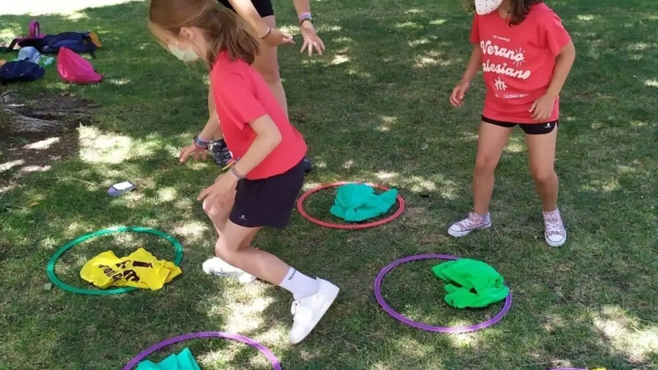 Dos ni&ntilde;as juegan en un campamento de los salesianos.