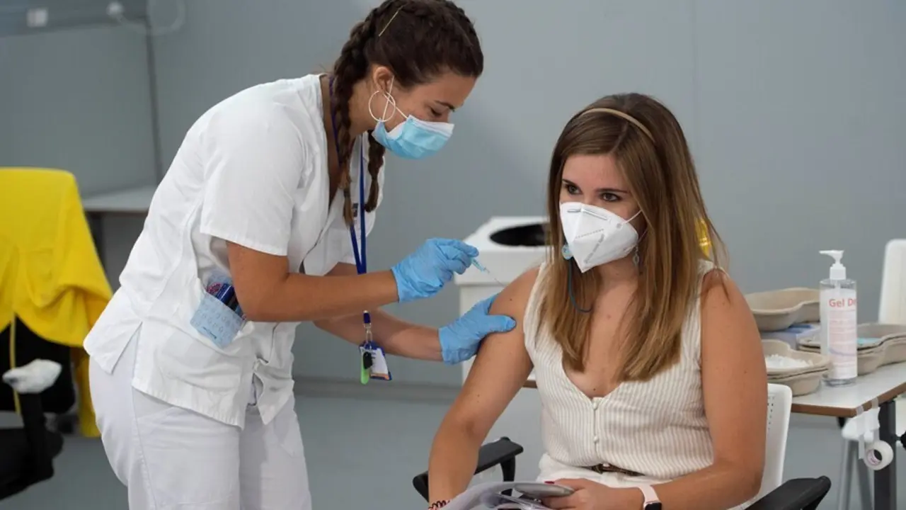 Una joven recibe la primera dosis de la vacuna Pfizer en el Hospital Zendal, en Madrid (Espa&ntilde;a).