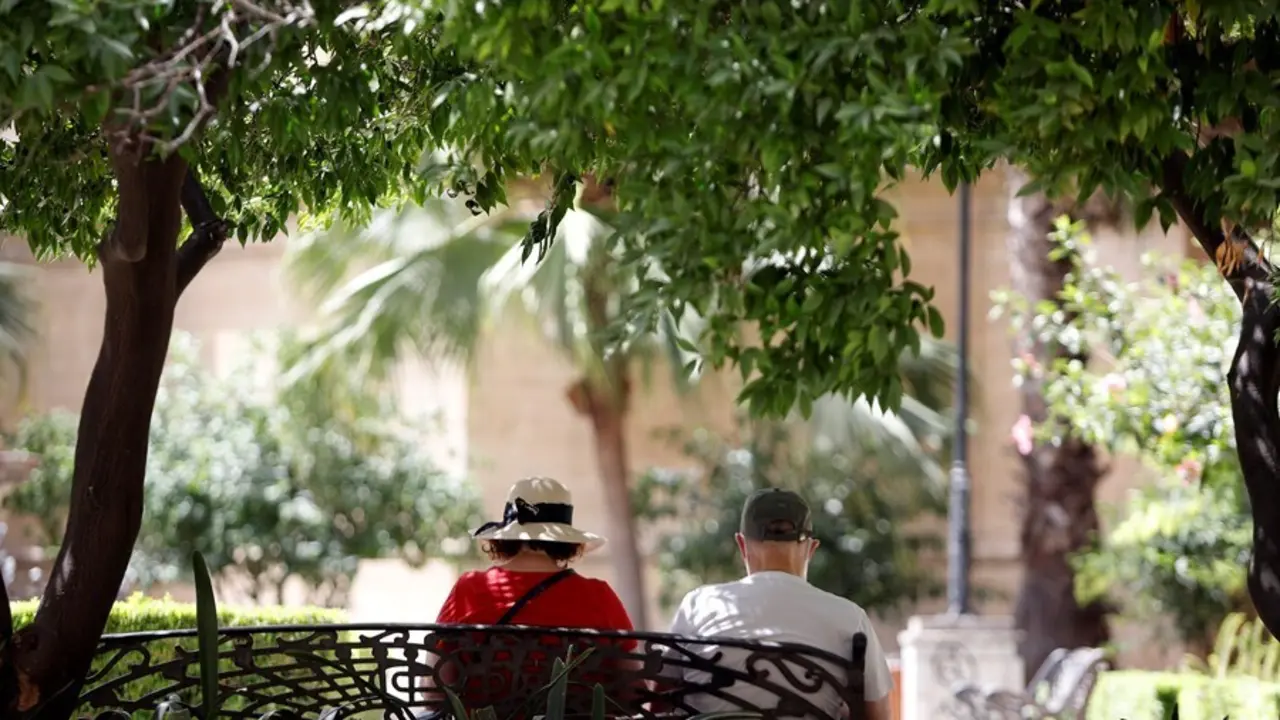 Varias personas intentan protegerse del calor en el d&iacute;a donde la capital andaluza se encuentra  en  aviso naranja por temperaturas que superar&aacute;n los 40 grados en algunos puntos de la capital y la provincia a 12 de julio del 2021 en M&aacute;laga (Andaluc&iacute;a). Se 