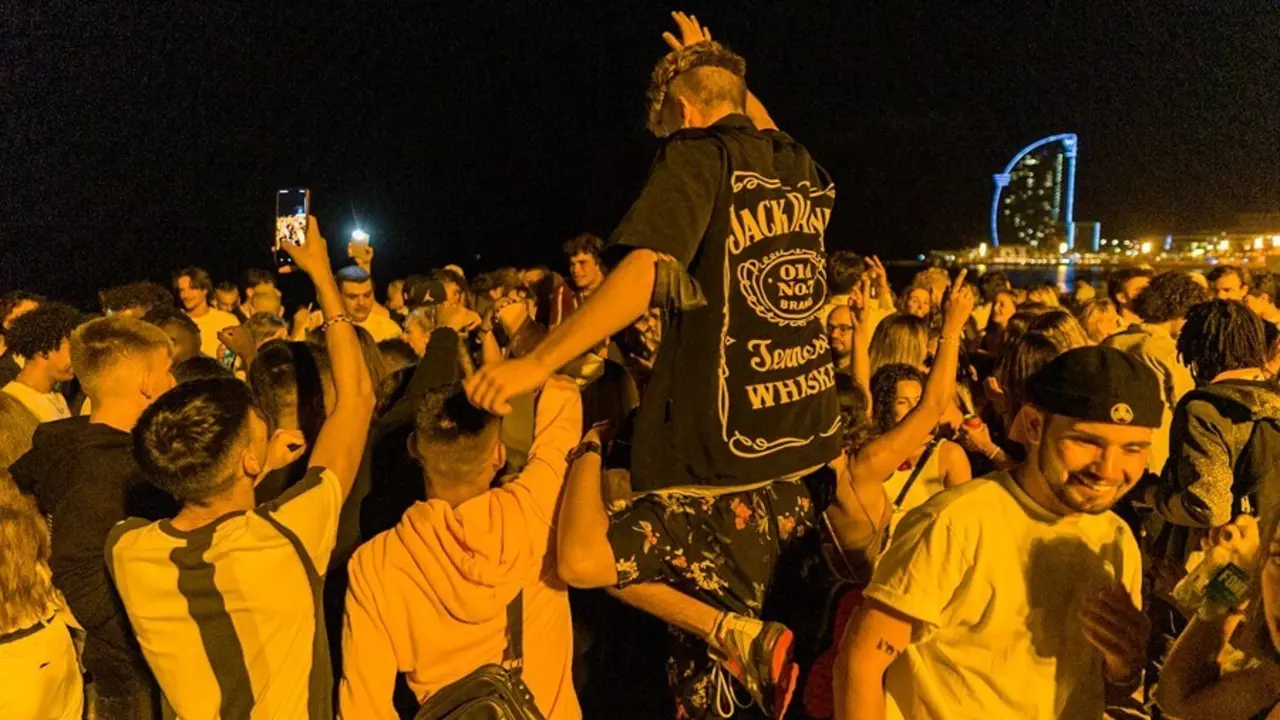 Varios grupos de j&oacute;venes en la playa de la Barceloneta horas antes de que entre en vigor el toque de queda en Catalunya