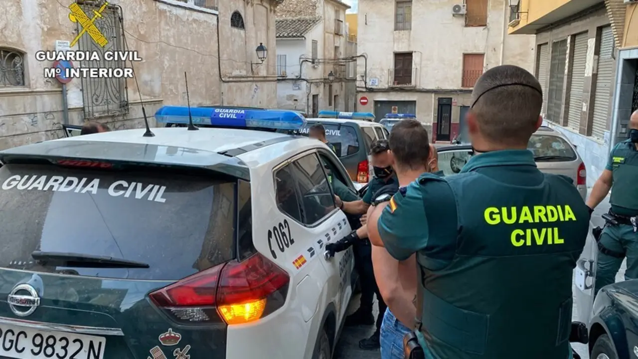 Agentes de la Guardia Civil trasladan a uno de los detenidos