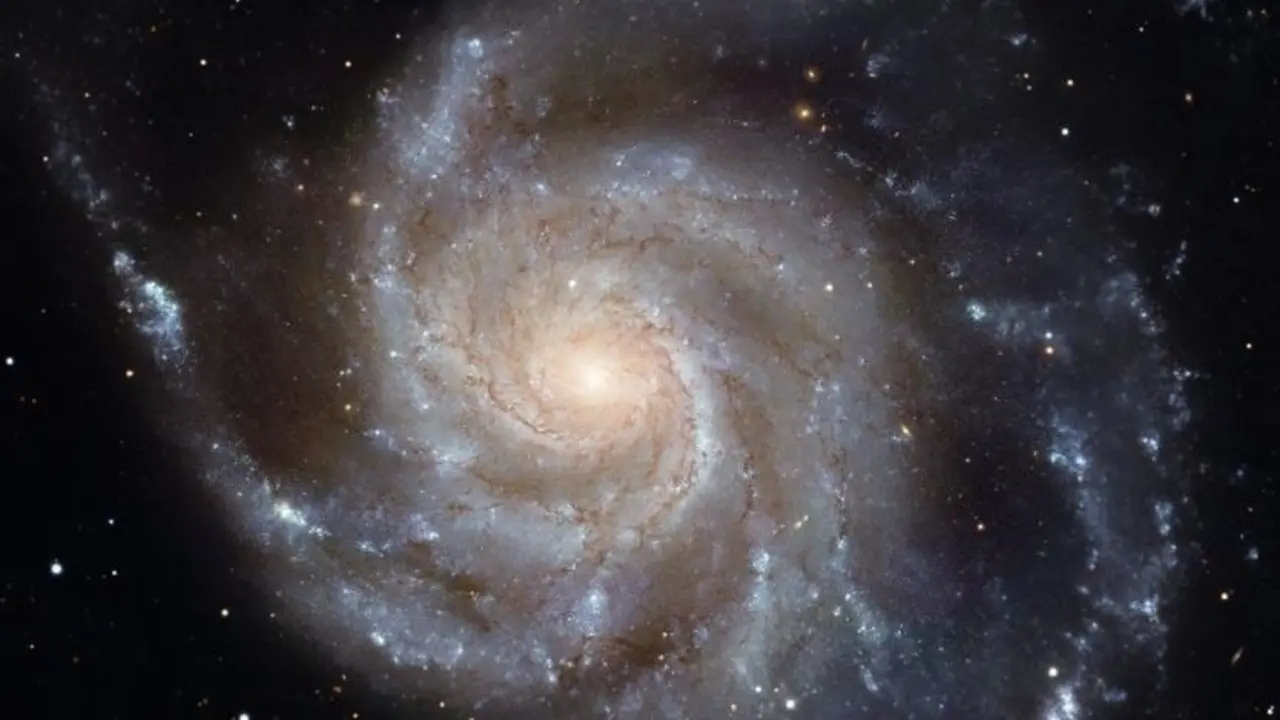 Una imagen de Messier 101, la Galaxia Molinillo, hecha con el Telescopio Espacial Hubble. Los grupos de color azul brillante en los brazos espirales son sitios de formaci&oacute;n estelar reciente.