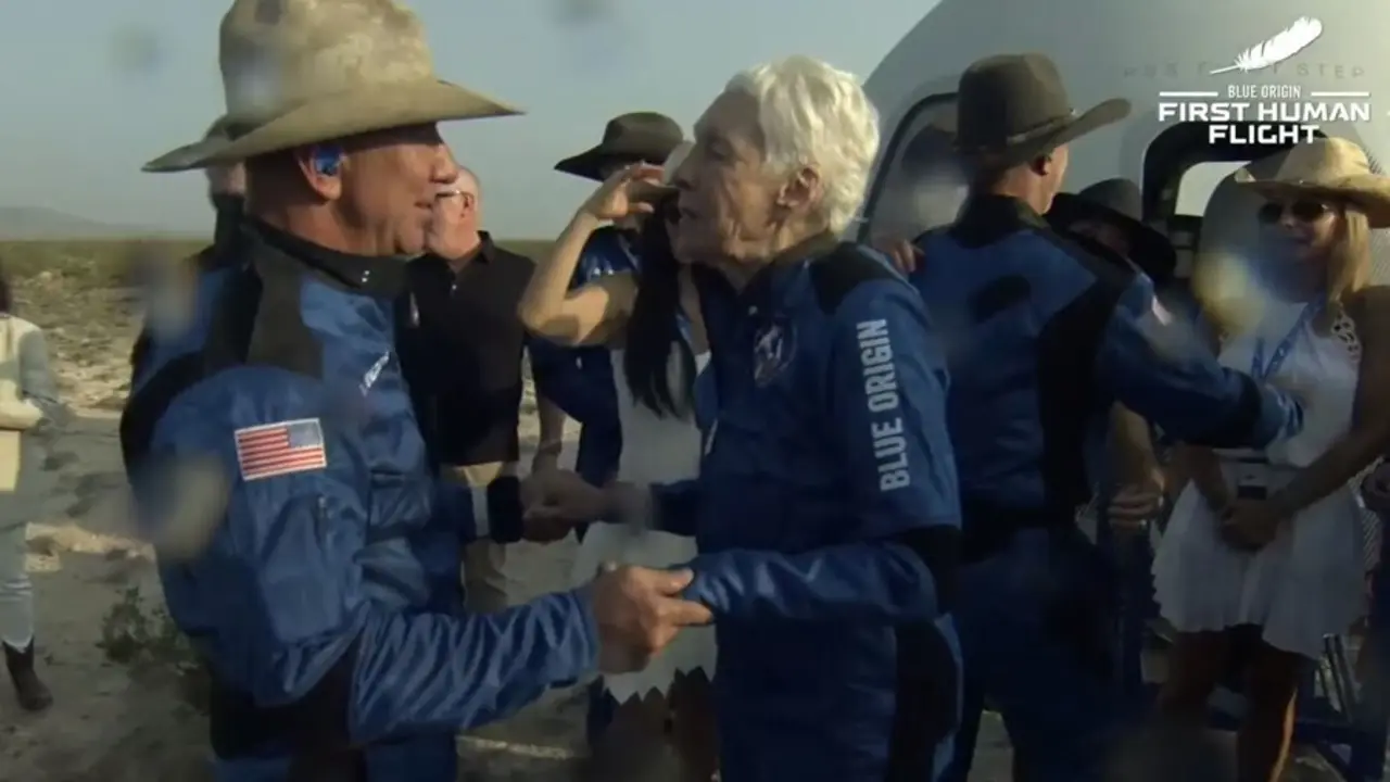 Jeff Bezos junto a la tambi&eacute;n pasajera Wally Funk, junto a la nave tras aterrizar