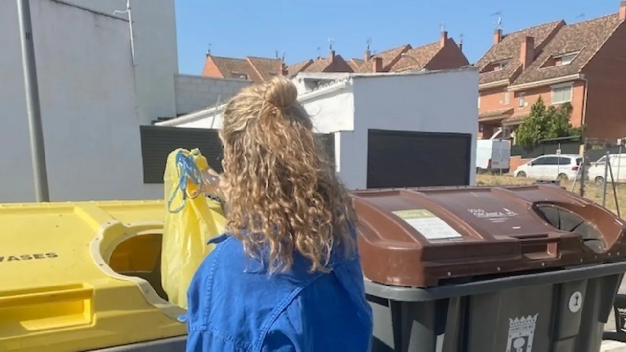 Una mujer deposita envases dom&eacute;sticos en el contenedor amarillo.
