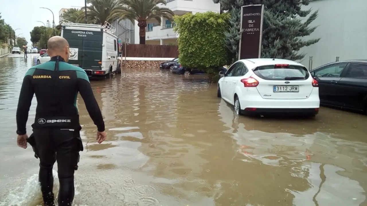 Archivo - Un agente camina en una carretera afectada por una inundaci&oacute;n en el sur de Mallorca.