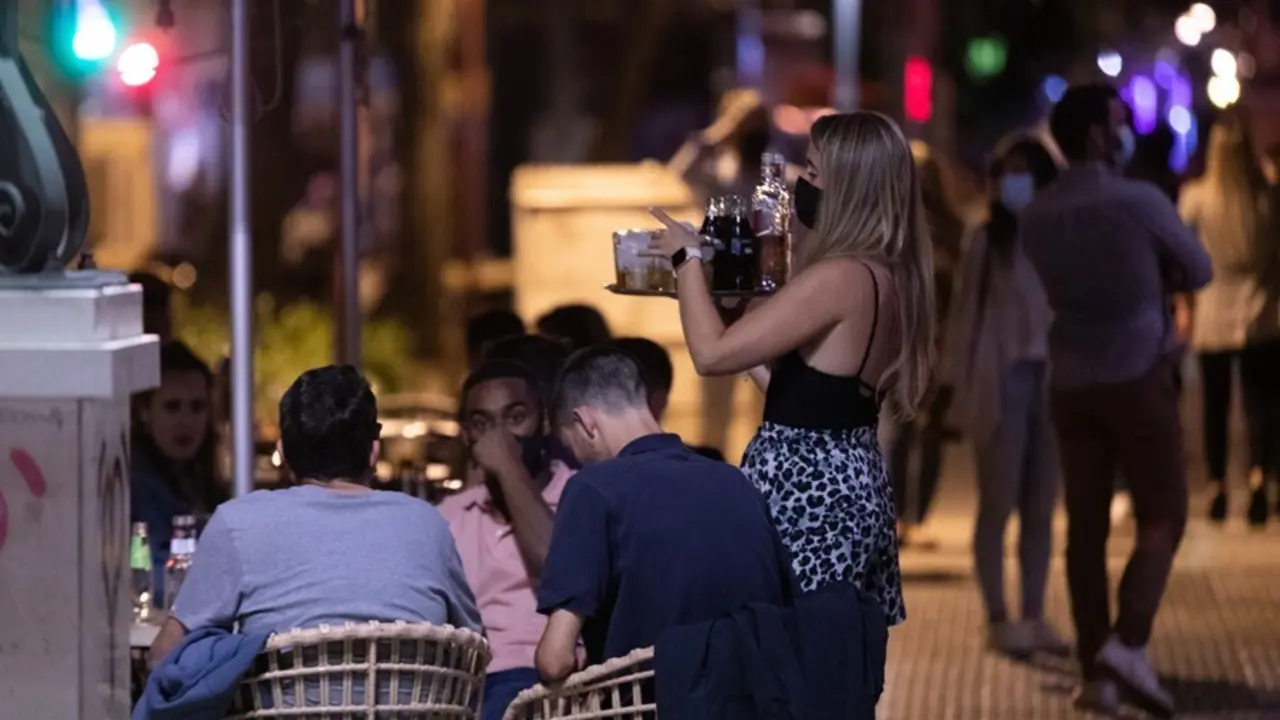 Archivo - Una camarera atiende a varias personas en la terraza de un bar de copas en la primera noche sin toque de queda tras el fin del estado de alarma, a 09 de mayo de 2021, en Sevilla (Andaluc&iacute;a, Espa&ntilde;a). Andaluc&iacute;a pone fin desde este domingo, al deca