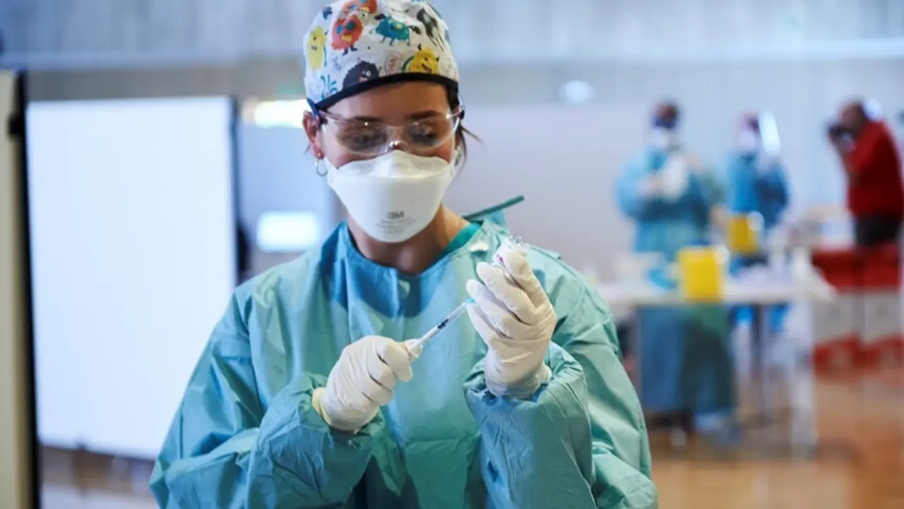 Archivo - Una profesional sanitaria sostiene un vial con la vacuna 