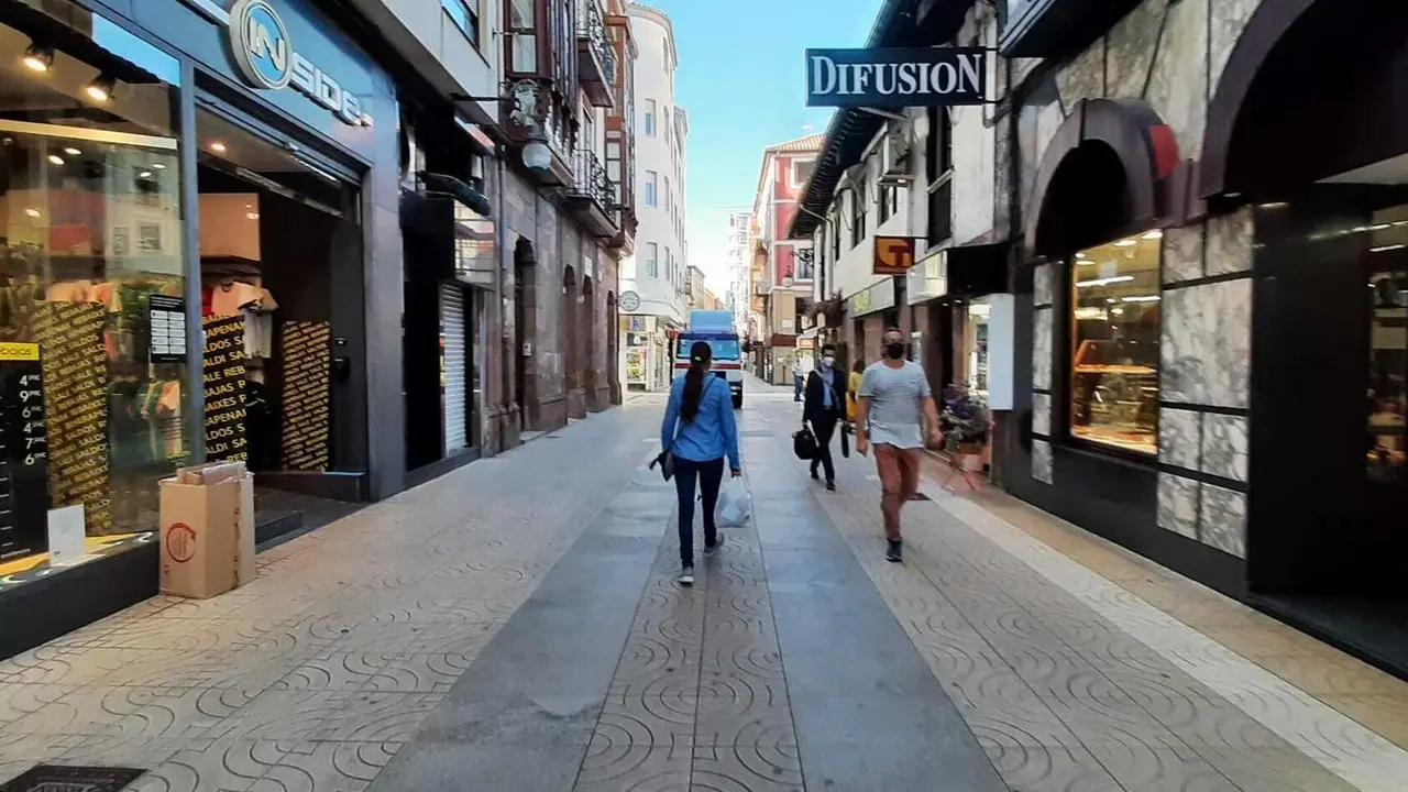 Varias personas con mascarilla por la calle Consolaci&oacute;n de Torrelavega. / S. D&iacute;az