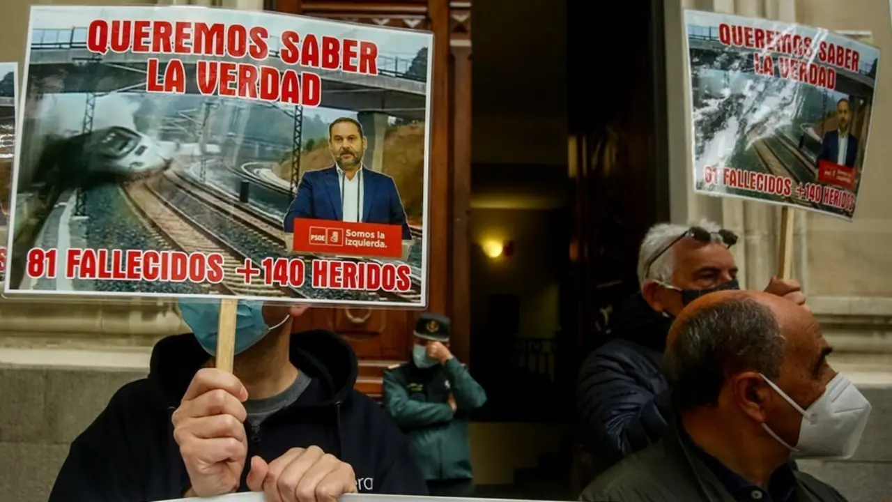 Archivo - Varias v&iacute;ctimas del accidente ferroviario del Alvia se concentran con una pancarta y carteles en los que se lee: "Queremos saber la verdad, 81 fallecidos + 140 heridos".