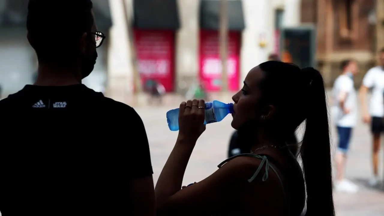 Varias personas intentan protegerse del calor en el d&iacute;a donde la capital andaluza se encuentra  en  aviso naranja por temperaturas que superar&aacute;n los 40 grados en algunos puntos de la capital y la provincia a 12 de julio del 2021 en M&aacute;laga (Andaluc&iacute;a). 