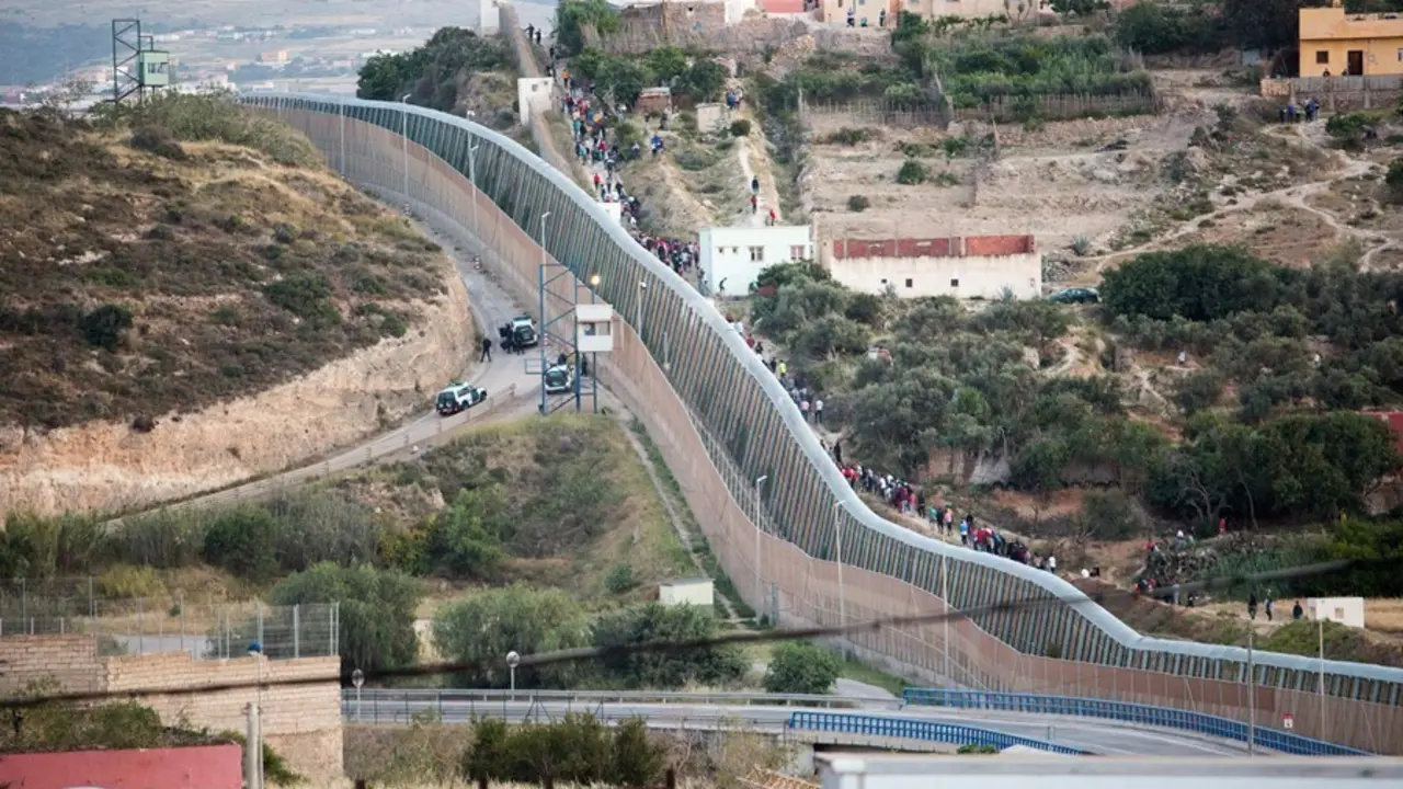 Archivo - Varios marroqu&iacute;es intentan llegar a suelo espa&ntilde;ol desde la frontera que separa Melilla y Marruecos, a 21 de mayo de 2021, en Marruecos.