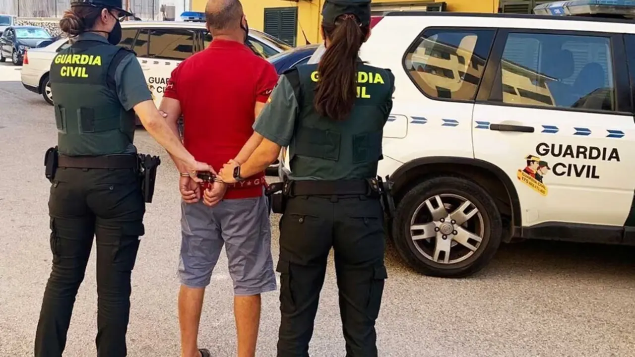 Dos agentes de la Guardia Civil junto al detenido.
