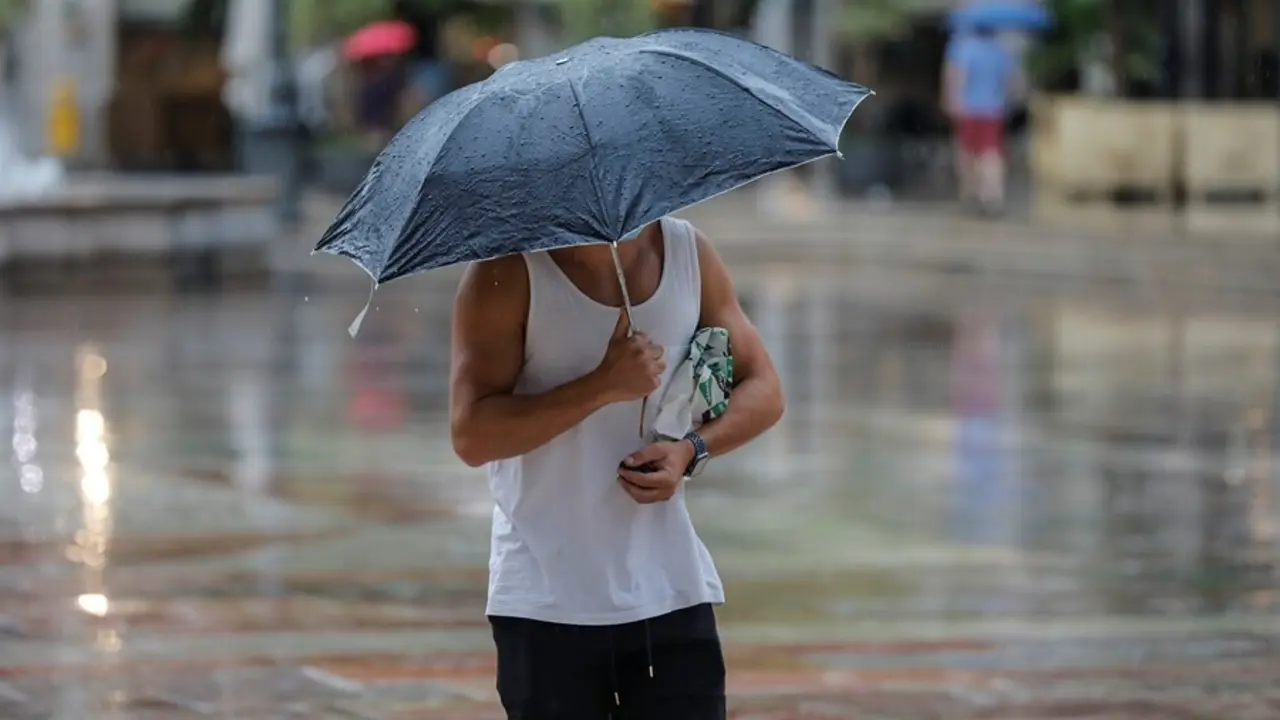 Una persona sostiene un paraguas mientras llueve, a 26 de julio de 2021, en Val&egrave;ncia. 