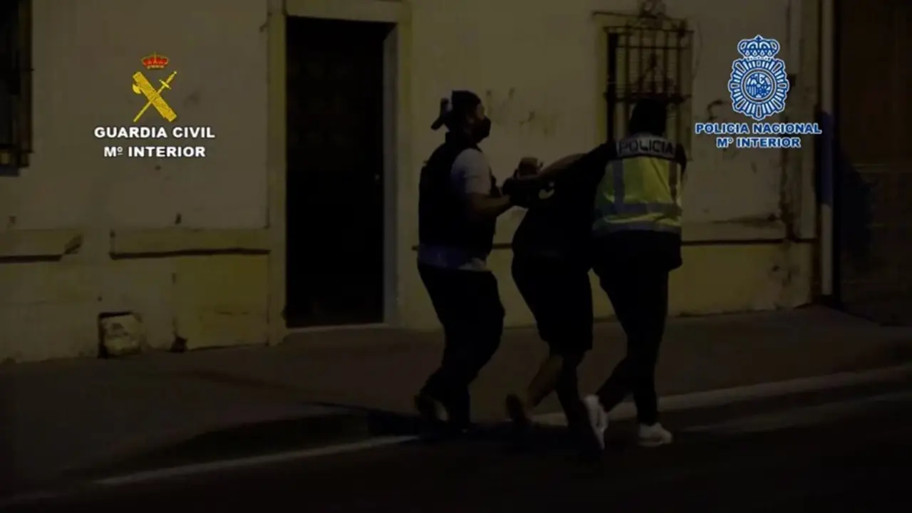Agentes de la Polic&iacute;a Nacional y Guardia Civil con uno de los detenidos
