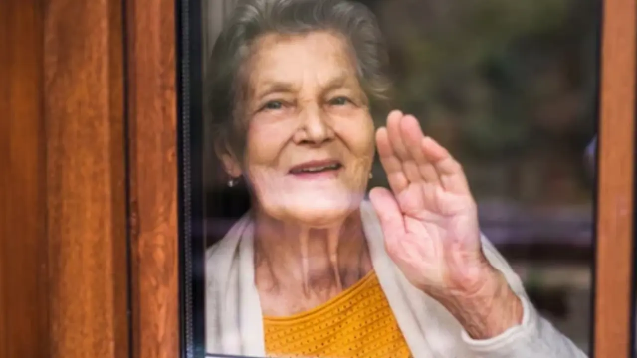Una anciana mirando por la ventana.