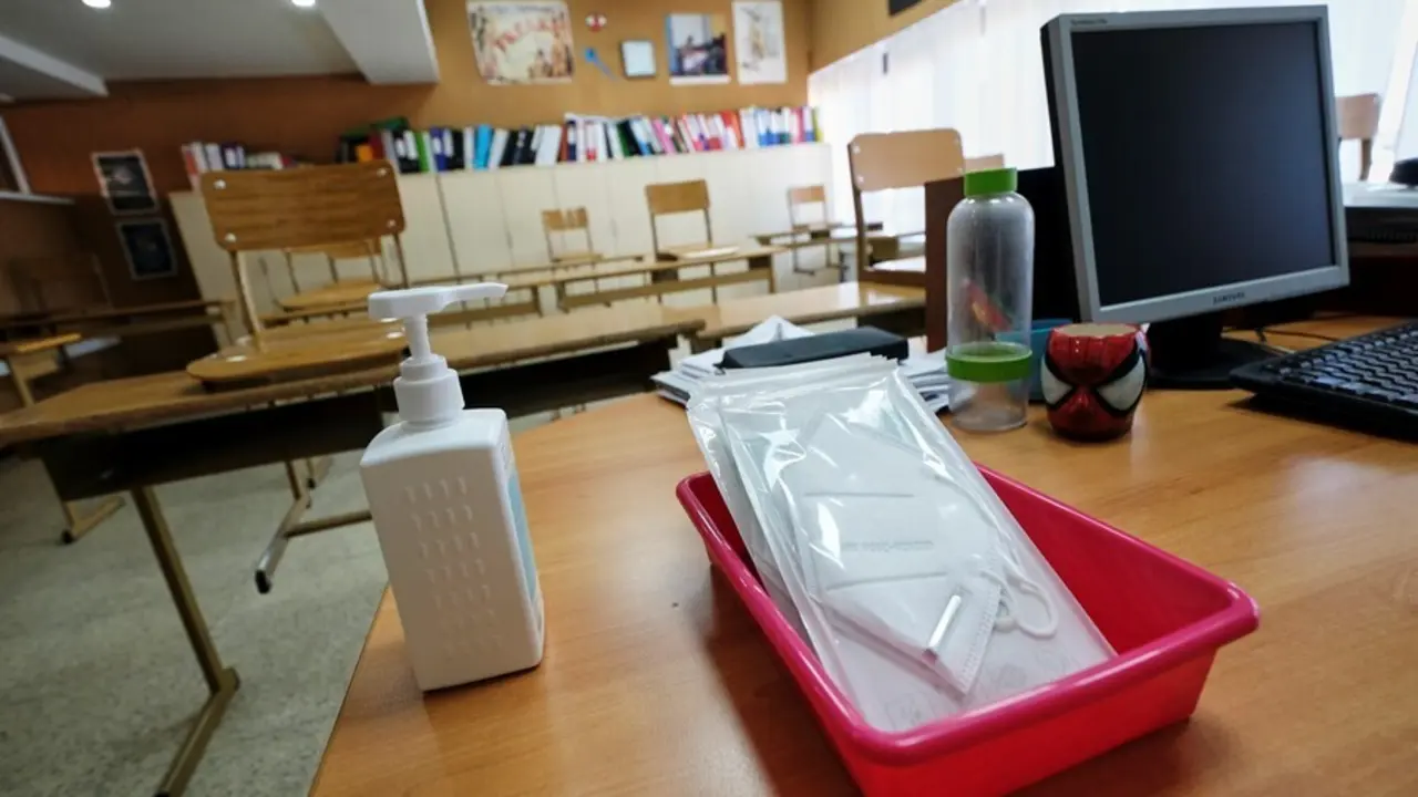 Archivo - Mascarillas y gel desinfectante en la mesa del profesor de un aula