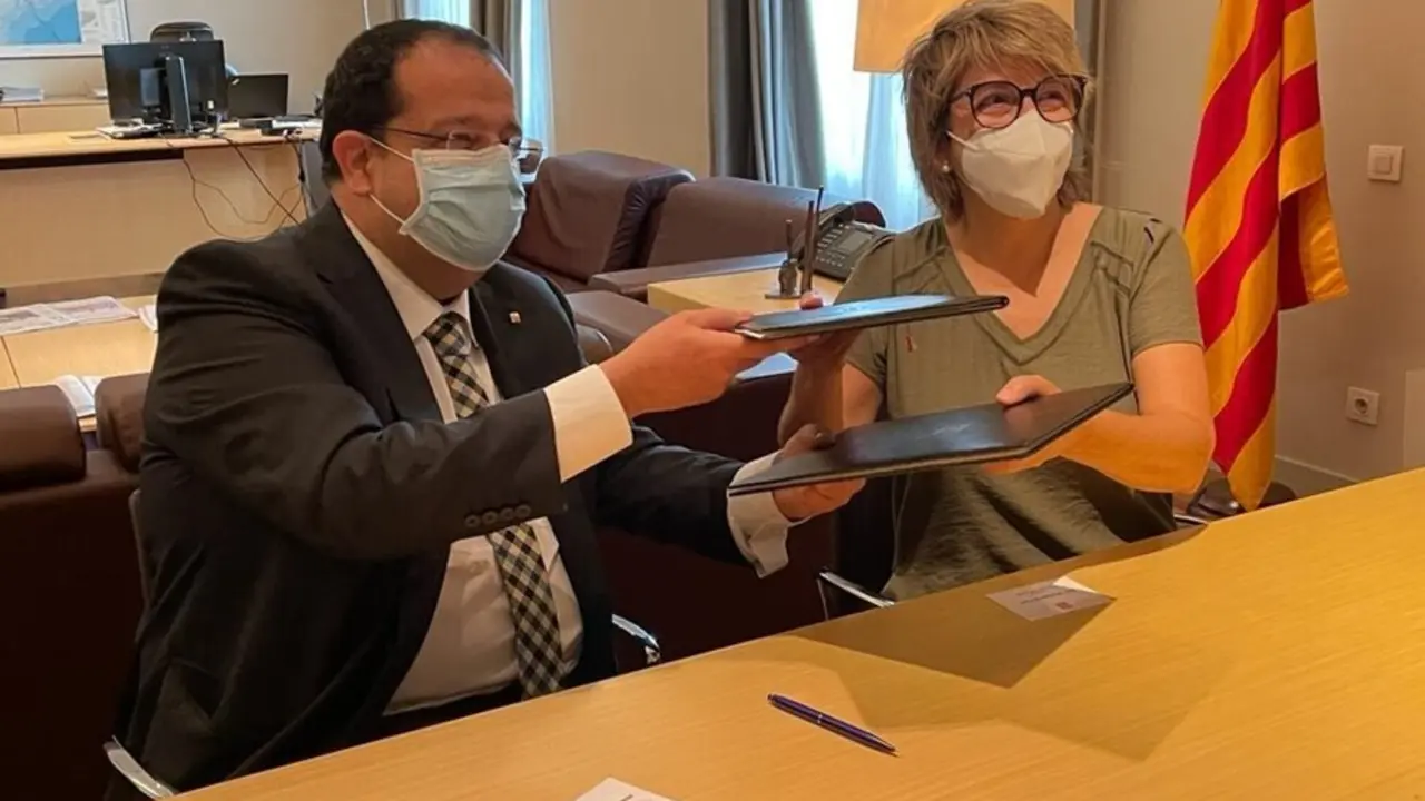 El conseller de Interior de la Generalitat, Joan Ignasi Elena, y la vicepresidenta primera de la Fundaci&oacute;n APIP-ACAM, Montserrat Font, firman un convenio de colaboraci&oacute;n contra el tr&aacute;fico de seres humanos. Barcelona, 30 de julio de 2021.