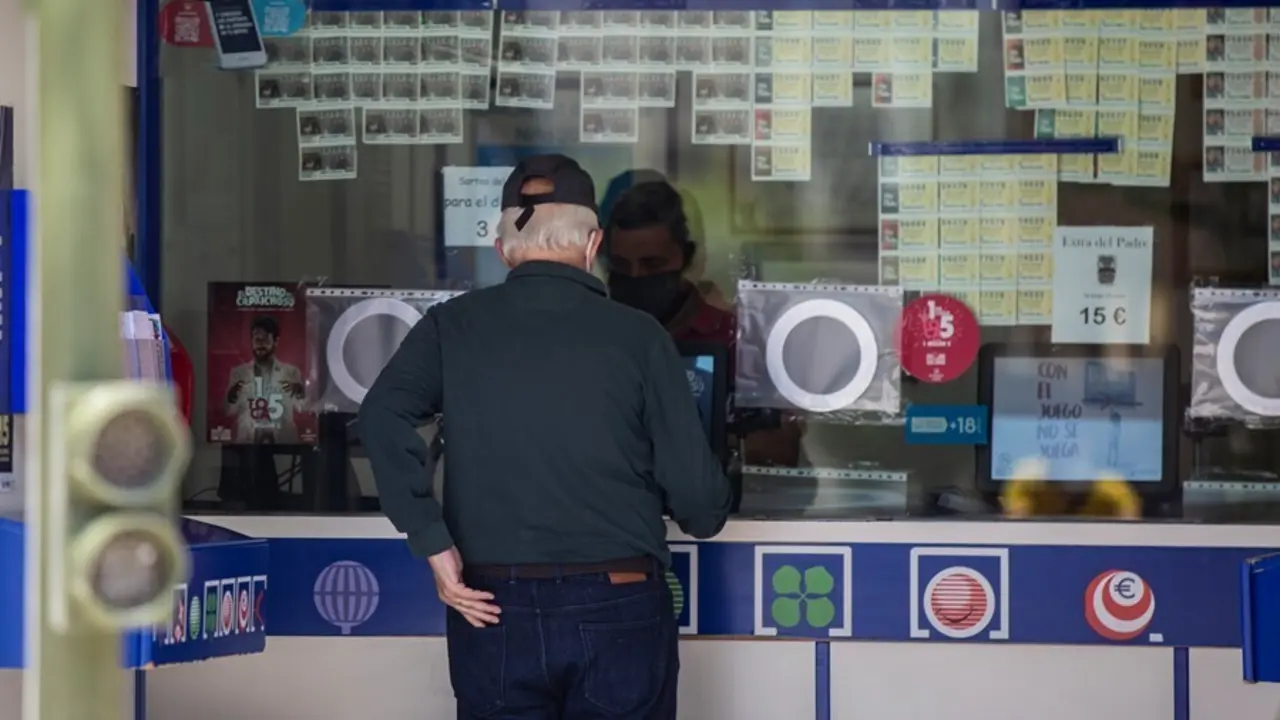 Archivo - Una persona compra loter&iacute;a en una administraci&oacute;n 
