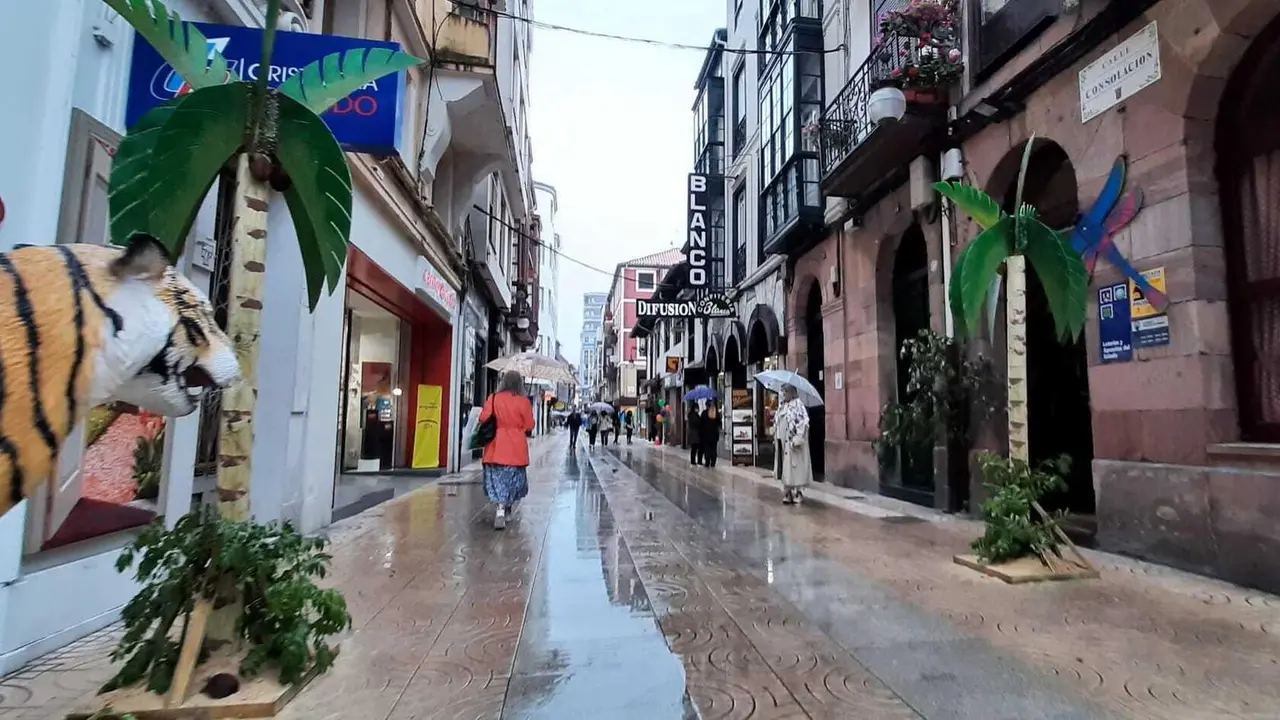 Varias personas transitan por la cale Consolaci&oacute;n de Torrelavega. / S. D&iacute;az