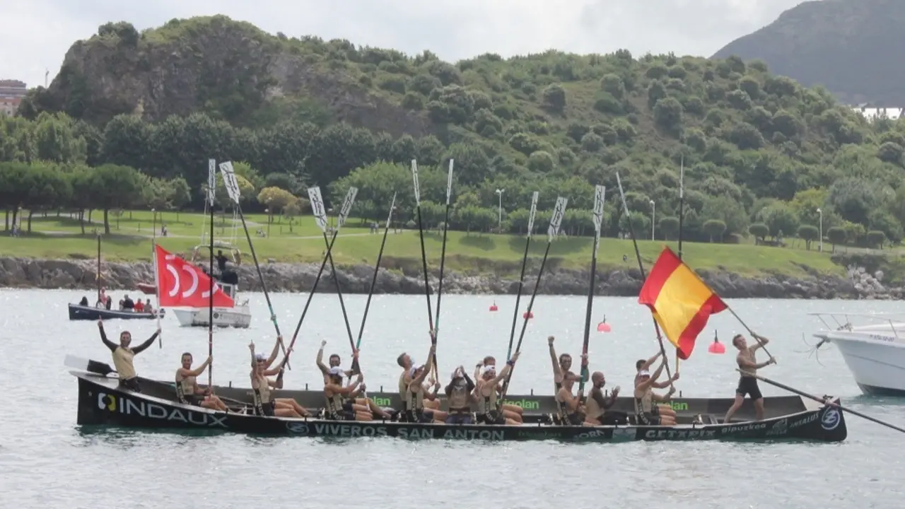 Los remeros de Getaria, con la bandera que les acreditaba como campeones de Espa&ntilde;a y con la que conmemoraba los quinientos a&ntilde;os desde la primera vuelta al Mundo de su paisano Elcano.