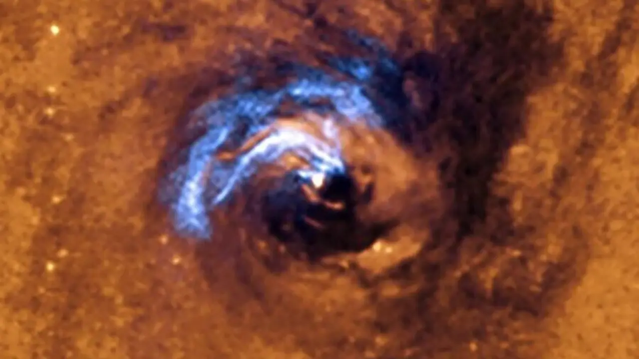 La imagen muestra el proceso de alimentaci&oacute;n nuclear de un agujero negro en la galaxia NGC 1566, y c&oacute;mo los filamentos de polvo, que rodean al n&uacute;cleo activo, quedan atrapados y giran en espiral alrededor del agujero negro hasta que se los traga.