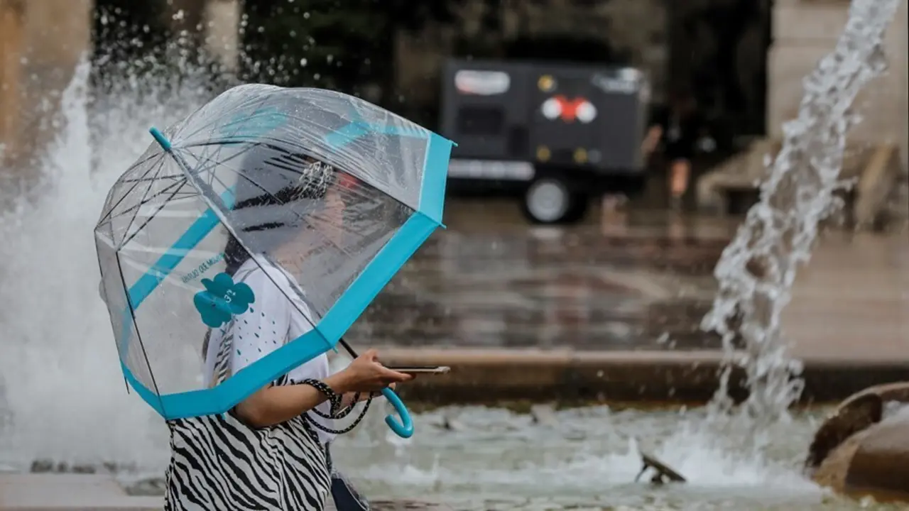 Una persona sostiene un paraguas mientras llueve