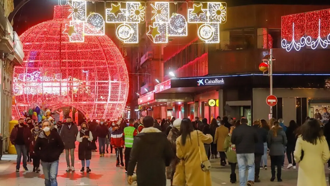 Archivo - Transe&uacute;ntes pasean bajo las luces navide&ntilde;as, en Vigo, en diciembre de 2020.