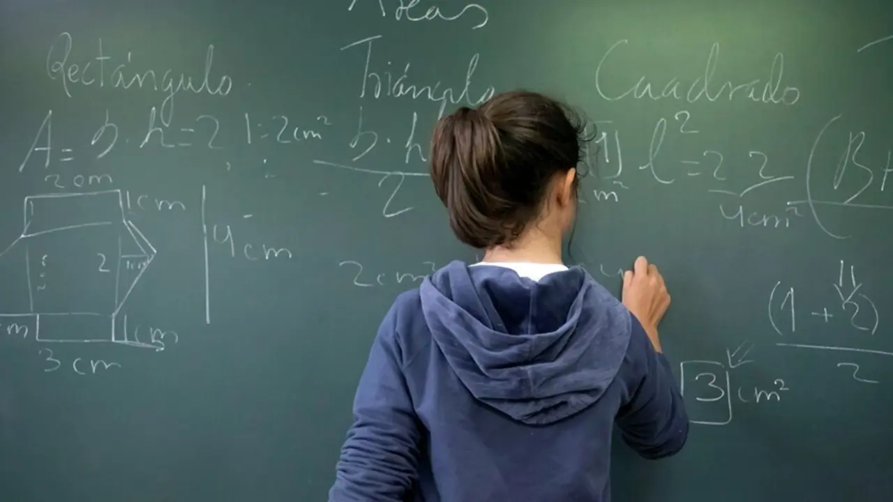 Archivo - Alumna escribe en una pizarra