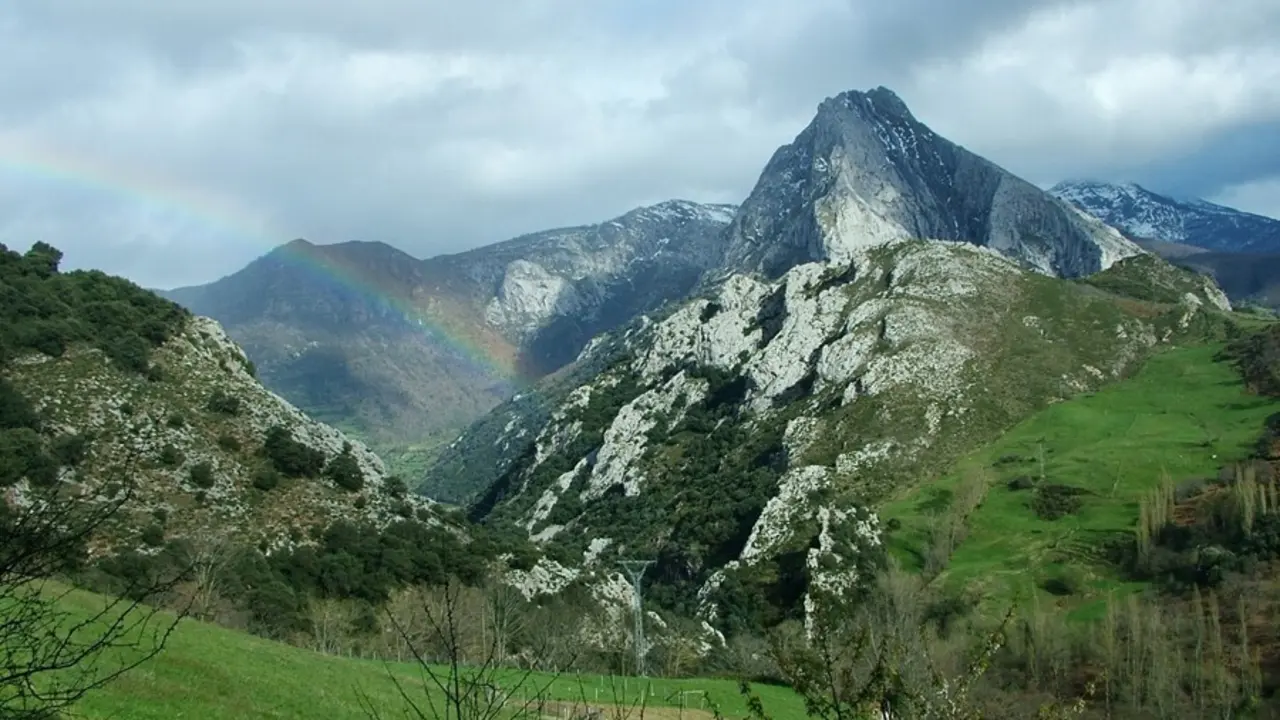 Archivo - Paisaje con monta&ntilde;as, nubes y arco iris