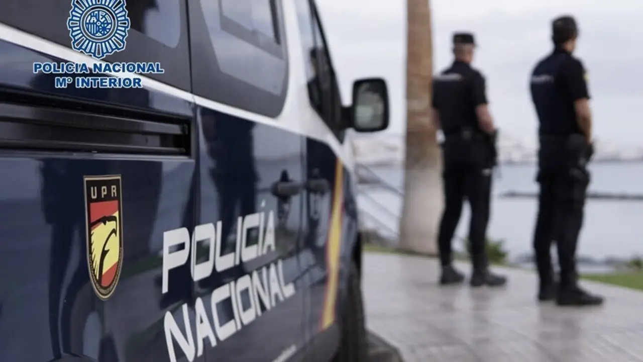 Archivo - Agentes de la Polic&iacute;a Nacional junto a un coche patrulla