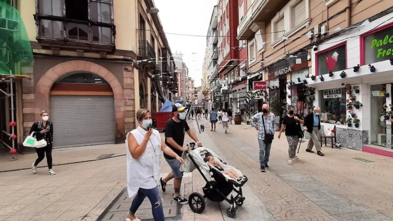 Varias personas transitan con mascarilla por la calle Escalante de Torrelavega. / S. D&iacute;az