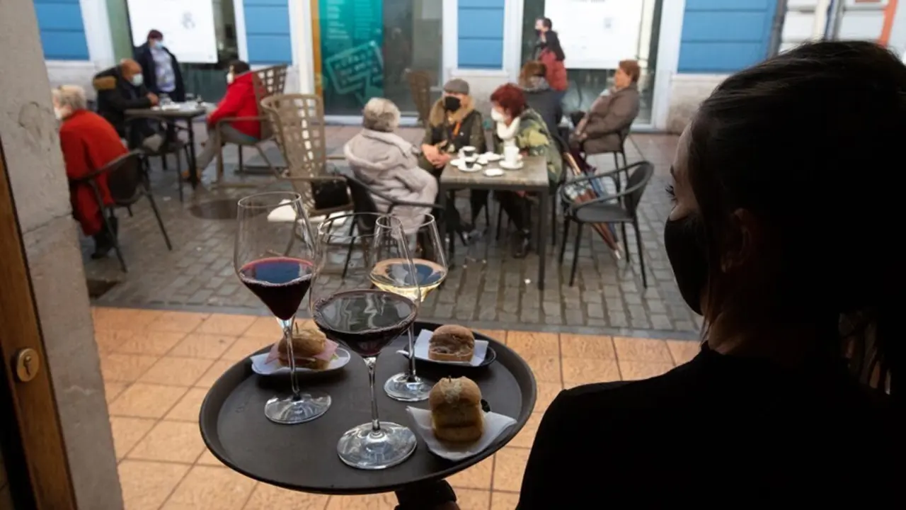 Archivo - Una camarera se dispone a servir en una terraza de un restaurante de Avil&eacute;s, Asturias (Espa&ntilde;a).