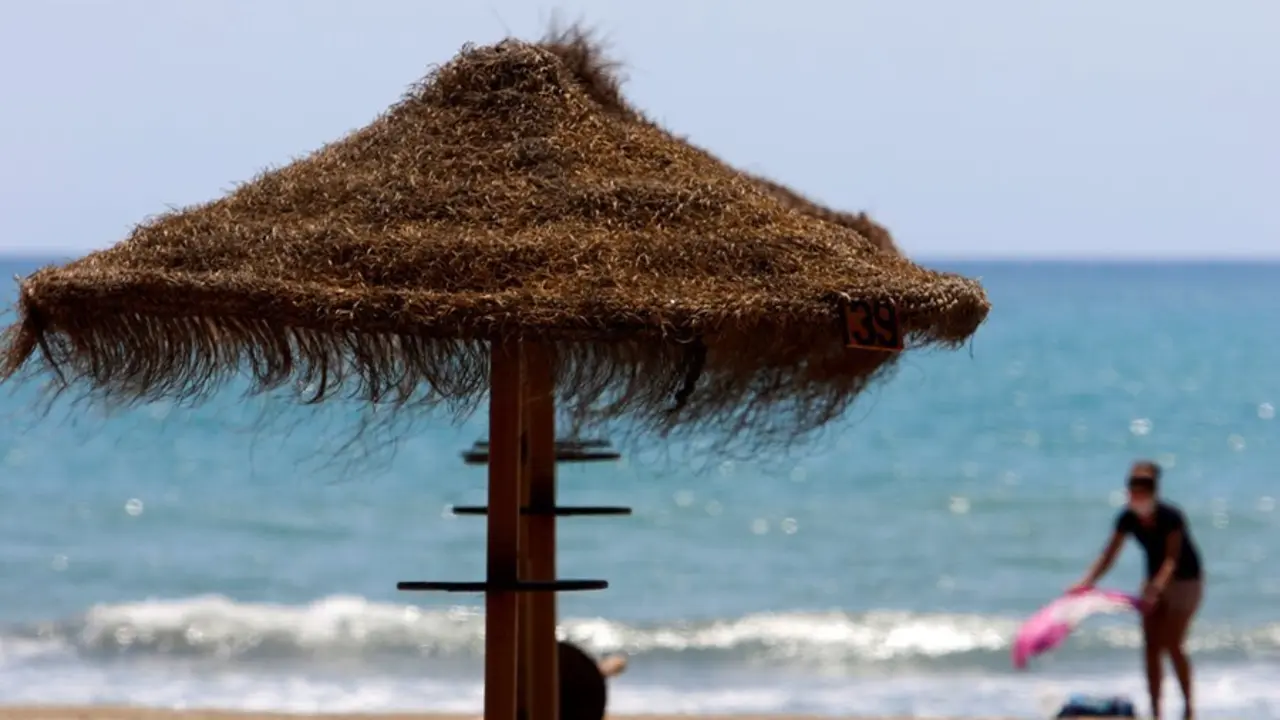 Archivo - Paseantes disfrutan de la playa de Sacaba en la barriada de Huel&iacute;n, en M&aacute;laga 