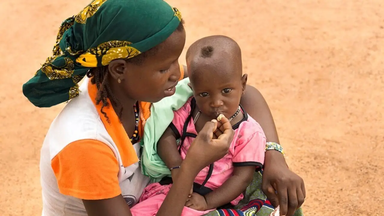 Archivo - Una madre da de comer a su hijo desnutrido en Burkina Faso
