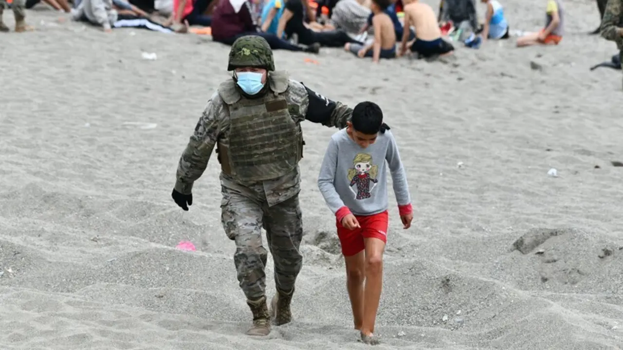 Archivo - Un militar del ej&eacute;rcito espa&ntilde;ol acompa&ntilde;a a un ni&ntilde;o en Ceuta